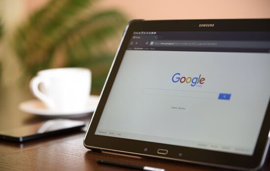 Mobiler Arbeitsplatz mit Tablet, Smartphone und Kaffee.