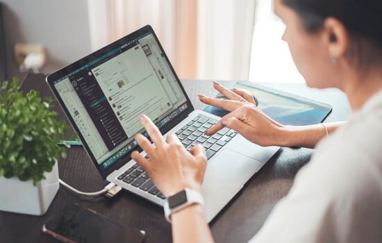 Eine Frau aktualisiert ihre Website am Laptop.